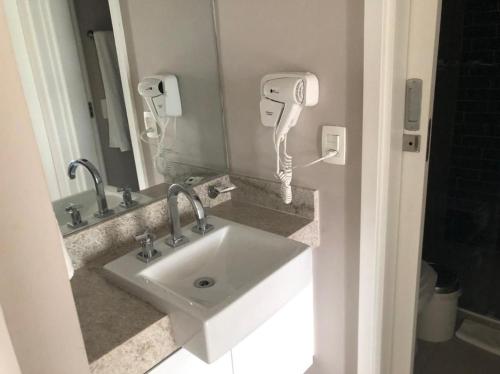 a bathroom with a sink and a phone on the wall at Estanconfor Santos com Vista Mar 2 in Santos