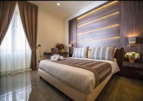 a bedroom with a large bed and a window at Palazzo Firenze in Naples