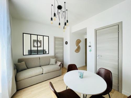 un salon avec une table blanche et un canapé dans l'établissement Deux pièces Neuf TURCKHEIM TUR201, à Cannes