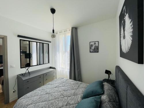 une chambre avec un lit, une commode et un miroir dans l'établissement Deux pièces Neuf TURCKHEIM TUR201, à Cannes