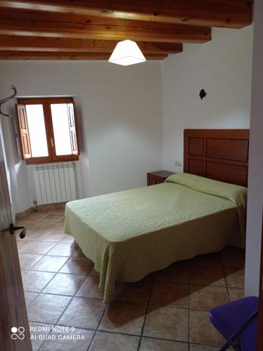 1 dormitorio con 2 camas y ventana en Casa Borro, en Salvatierra de Esca
