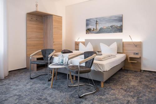 a hotel room with a bed and a table and chairs at Villa Ludwigsburg in Kühlungsborn