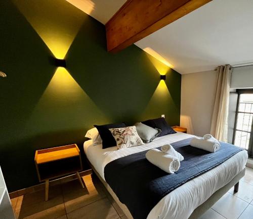 - une chambre dotée d'un lit avec un mur vert dans l'établissement Les Demoiselles de la Tour !, à Carcassonne