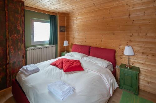 um quarto com uma cama grande num chalé de madeira em casa Balto em Passo del Tonale
