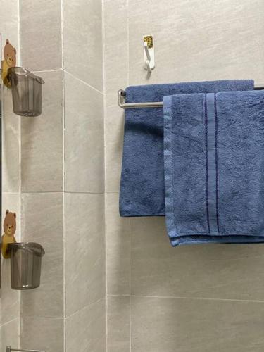 a bathroom with blue towels hanging on a wall at Home stay Hồ Thị Kỷ in Ho Chi Minh City