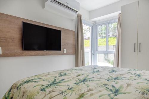 a bedroom with a bed and a flat screen tv at In Mare Bali Resort Beira Mar by Qavi - 109 in Parnamirim