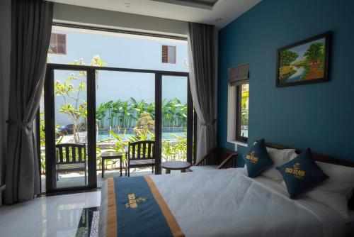 1 dormitorio con cama y ventana grande con vistas en Coco Island Villa, en Hoi An