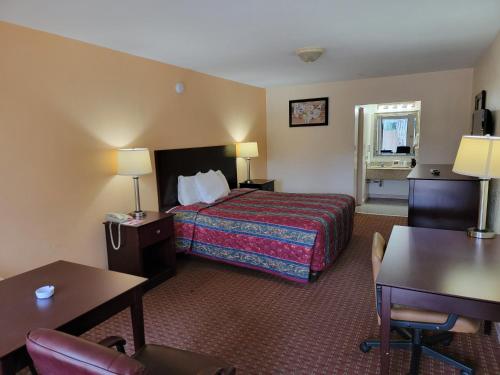 Habitación de hotel con cama y escritorio en Twin Star Lodge, en Biloxi
