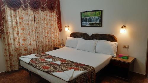 1 dormitorio con 1 cama grande con sábanas blancas en Gokulam Homestay en Kovalam