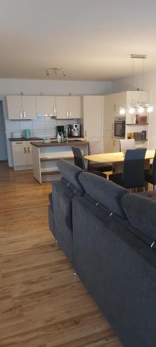 ein Wohnzimmer mit blauen Sofas und eine Küche in der Unterkunft Kleines Schmuckstück in Ermstedt