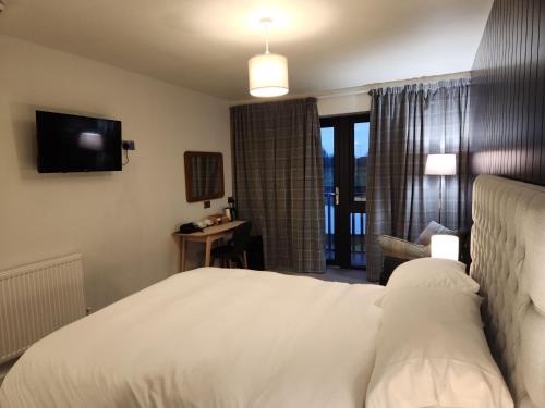 a hotel room with a bed and a television at The Swan - A Colombo Edition Hotel in Ely