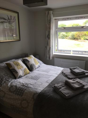 a bedroom with a bed with a window and towels on it at Woodview Lodge in Chesterfield