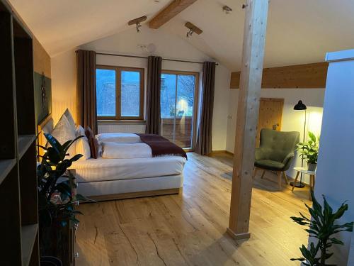 ein Schlafzimmer mit einem Bett und einem grünen Stuhl in der Unterkunft Bergsteiger-Hotel "Grüner Hut" in Bad Hindelang