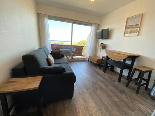 un salon avec un canapé et une table dans l'établissement Studio 2 personnes superbe vue mer à 50m de la plage du Fort Bloqué - JULIAN, à Ploemeur
