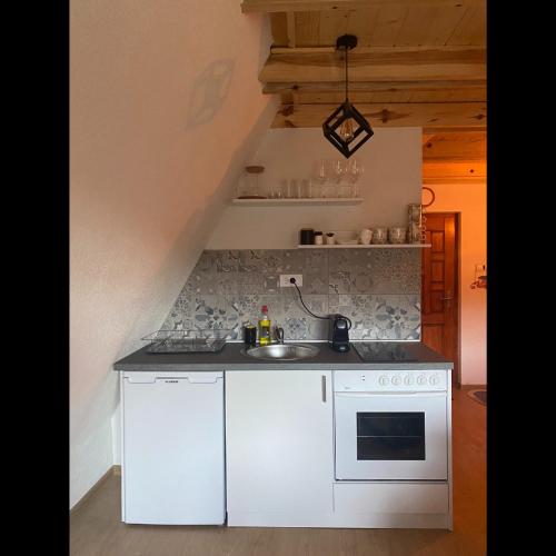 a white kitchen with a sink and a stove at The Tara Concept in Šljivovica
