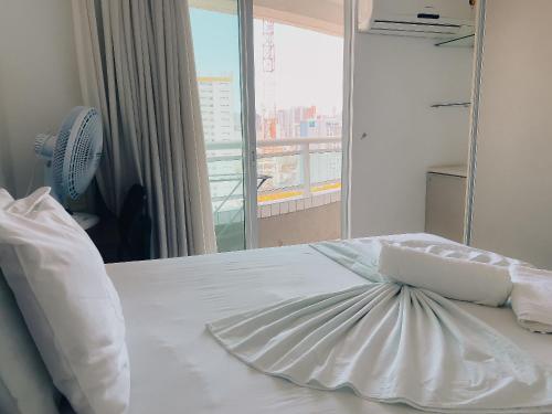 a bedroom with a white bed with a window at Studio Iracema in Fortaleza