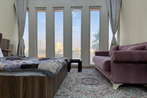 a bedroom with a bed and a couch and a window at Cozy 1 Bed in Sports City in Dubai