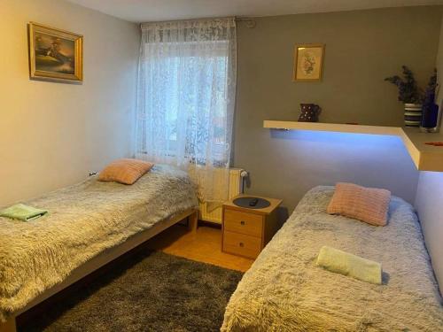 a bedroom with two beds and a window at U Wojciecha in Duszniki Zdrój