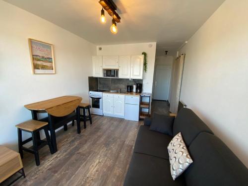 un salon et une cuisine avec un canapé et une table dans l'établissement Studio 2 personnes superbe vue mer à 50m de la plage du Fort Bloqué - JULIAN, à Ploemeur
