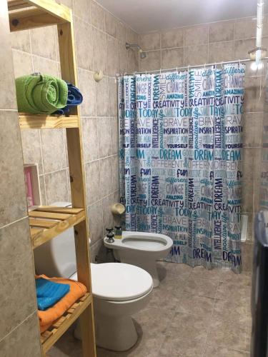 ein Bad mit einem WC und einem Duschvorhang in der Unterkunft Casa por día in Olavarría
