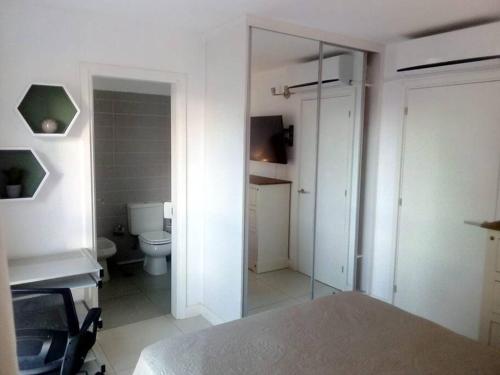 Habitación con baño con cama y aseo. en Lux Tower Departamento 2 ambientes para 2 a 4 personas, en Punta del Este