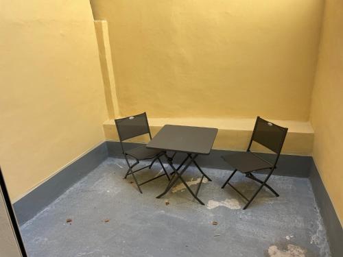 uma pequena mesa e duas cadeiras num quarto em Studio avec terrasse au calme Centre ville - NEG1 em Cannes