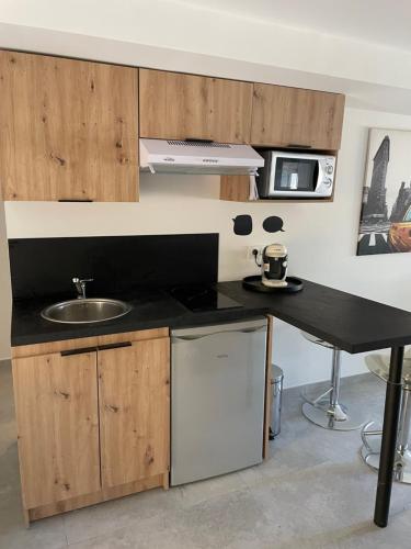 uma cozinha com um lavatório e uma bancada em Studio avec terrasse au calme Centre ville - NEG1 em Cannes