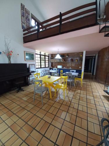 um quarto com uma mesa e cadeiras e um piano em HOSTEL Recanto do Cajueiro em Maceió