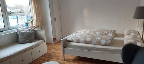 Dieses weiße Zimmer verfügt über einen Stuhl und ein Fenster. in der Unterkunft Kleines Schmuckstück in Ermstedt