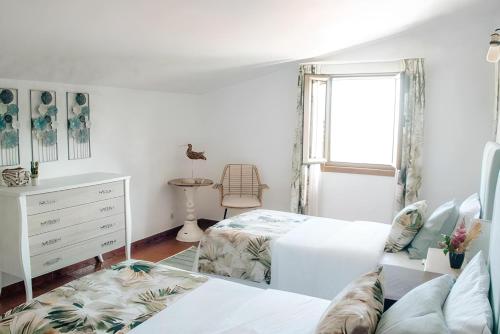 um quarto com uma cama, uma cómoda e uma janela em Casa Bela Vista de Moledo em Moledo