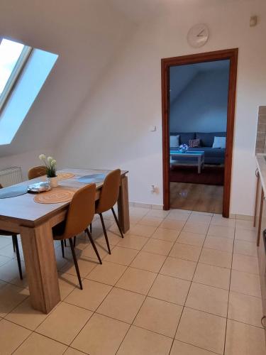 a dining room with a table and chairs and a couch at Bohém Apartman in Nyergesújfalu