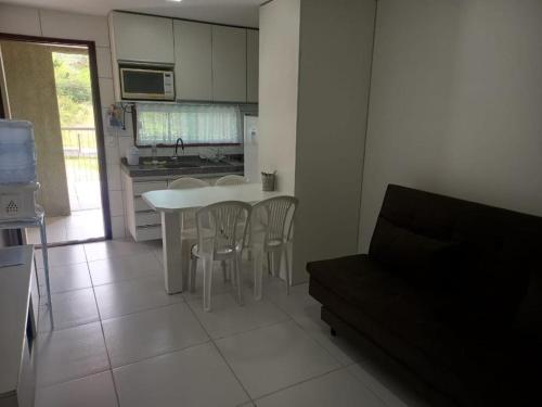 uma cozinha com uma mesa branca e cadeiras num quarto em FLAT VILLA MONTE CASTELO em Bezerros