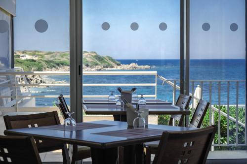 2 mesas en un restaurante con vistas al océano en Hôtel Propriano Arena Bianca, en Propriano