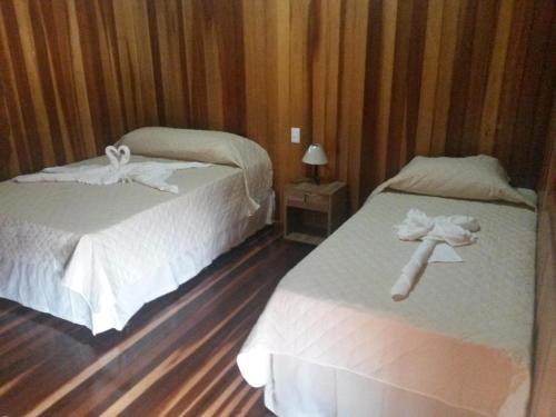 Dos camas en una habitación de hotel con toallas. en Pousada Shekinah, en Olímpia
