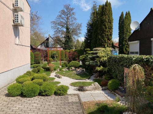 un jardín con un sendero de piedra y arbustos en Nyaraló Japánkerttel - Apartment with Japanese Garden en Balatonmáriafürdő