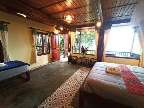 a bedroom with a bed in a room with windows at Puluong Home in Pu Luong
