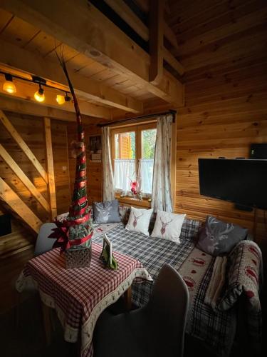 una sala de estar con una mesa en una cabaña de madera en Hunting Lodge Lipót en Lipót