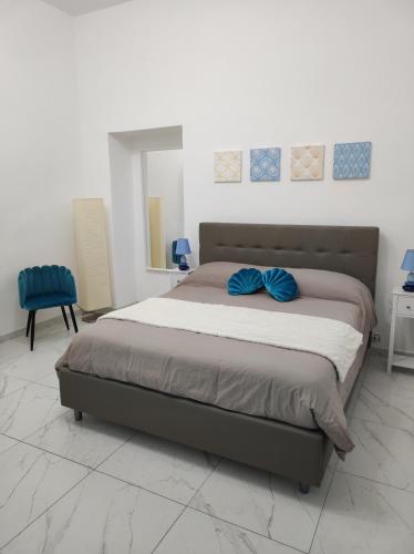 una camera da letto con un letto con cuscini blu di Casa della Sibilla a Napoli