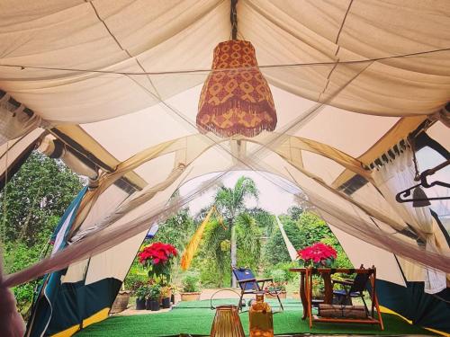 a tent with a chandelier and chairs in it at Villa Noina Glamping in Ban Nong Takhain