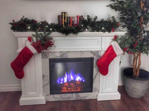 a living room with a fireplace with santa claus mittens at Romantic Studio Cottage in Lambton Shores