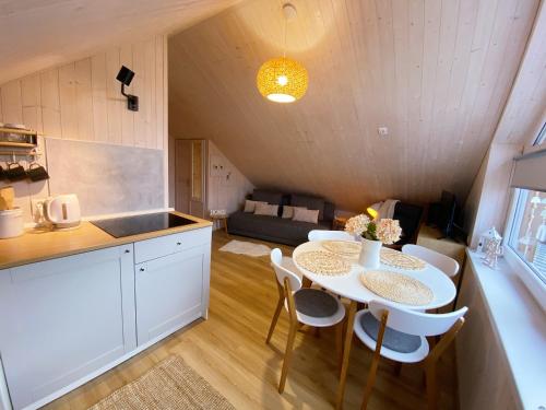 a kitchen and dining room with a table and chairs at Apartamenty Jagodzianka - Jacuzzi, Sauna, Tężnia solankowa in Ustrzyki Dolne
