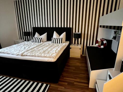 um quarto com uma cama com almofadas pretas e brancas em Ferienwohnung PuraVida Ostsee 5B em Bastorf
