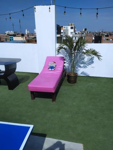 a pink bench sitting on top of a green floor at Ambigua Hospedaje in Trujillo