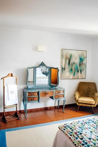 a bedroom with a dressing table and a chair at Casa Bela Vista de Moledo in Moledo