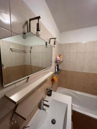 a bathroom with a sink and a mirror and a tub at Apartman West - private parking place in Zagreb