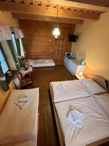 a room with two beds and a table in it at Villa Victoria Penzion in Liptovský Ján