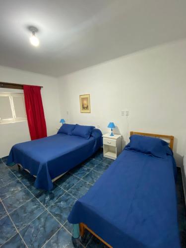 2 camas en una habitación con sábanas azules en Nonno Coletto en Tupungato