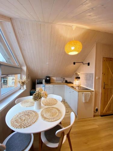 a kitchen and dining room with a table and chairs at Apartamenty Jagodzianka - Jacuzzi, Sauna, Tężnia solankowa in Ustrzyki Dolne