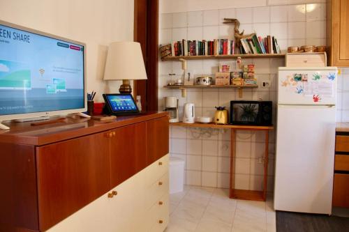 een keuken met een televisie op een aanrecht met een koelkast bij Kubri Home ! A Confortable space for Mind & Soul. in Pellezzano