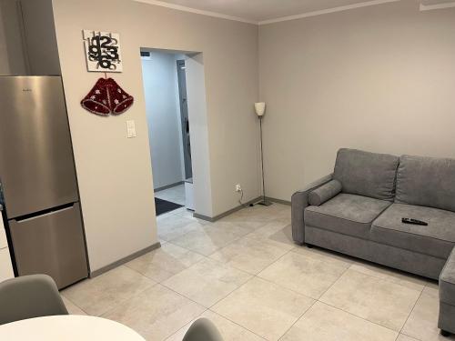 a living room with a couch and a refrigerator at Apartament, noclegi na doby - Raczki k. Suwałk in Raczki
